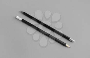 Two black pencils with copy space on gray paper background.