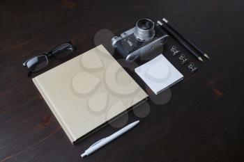 Blank vintage stationery and retro photo camera on wooden background.