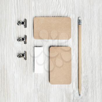 Responsive design template. Blank kraft business cards, pencil and eraser on light wood table background. Flat lay.