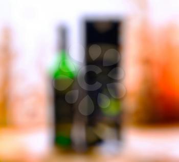 Vertical bottle of alcohol with glass and box bokeh background