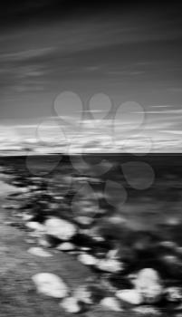 Vertical black and white dramatic stony beach motion blur abstraction background backdrop