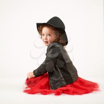 Little girl with black hat sitting and shy