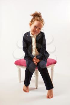 Little girl in black suit sitting and smiling