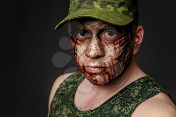 Portrait of Soldier with Military Style Camouflage on a  Face.  Portrait  on black background