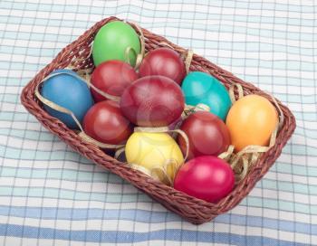Basket with colorful easter eggs on checkered