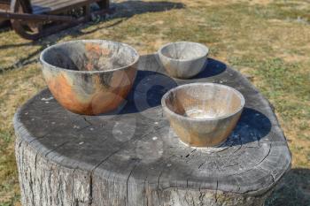 Three wooden bowl on a stump. Wooden utensils