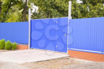 Blue gate and fence. Fence of the private house with blue fence and a gate.