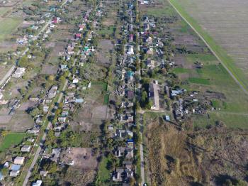 Top view of the village. One can see the roofs of the houses and gardens. Road the village. Village bird's-eye view.