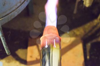 Heating a steel pipe with a blowtorch. The flame of a blowtorch.