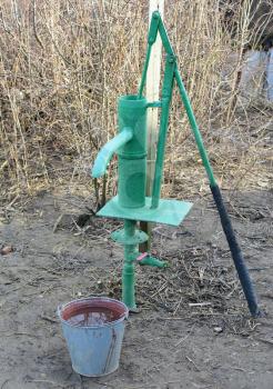 Hand pump leading to an artesian well. Pumping water for watering the garden.