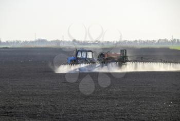 The tractor sprayed herbicides on the field. Chemistry in agriculture.