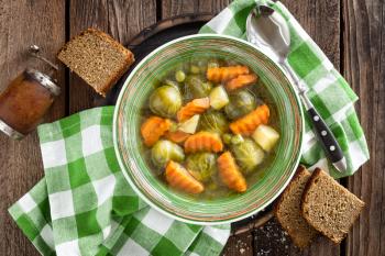 Vegetable soup with brussel sprouts on wooden rustic table, top view