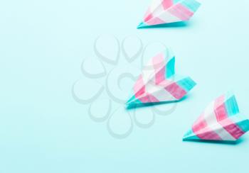 Paper airplane in transgender flag on a blue background