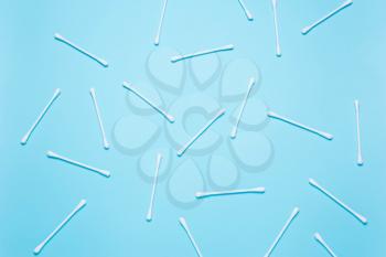 White cotton buds on blue background. Concept of cleanliness, makeup, body care. Top view, flat