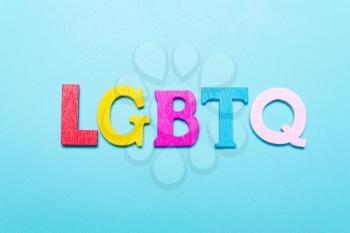 LGBTQ word from rainbow color letters on a blue background