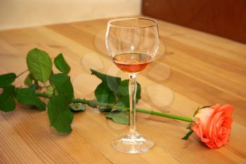 Rose and cognac on wooden floor. Element of design.