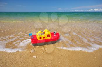 Toy ship on the sea shore. Nature and conceptual design.