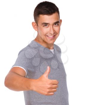 Cheerful young man showing thumb up sign, isolated over white