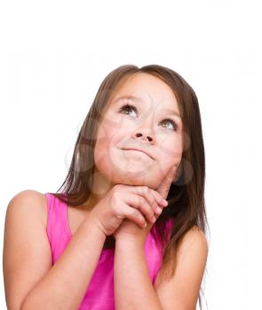 Cute girl is holding her face in astonishment and looking up, isolated over white