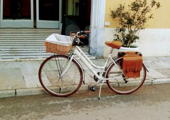 Vintage bike for a picnic and shopping stands near the brick wall of the Italian city.