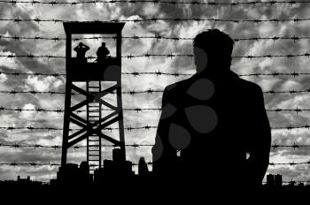Refugees concept. Silhouette refugee man near the border area against the background of the urban landscape