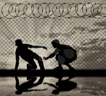 Concept of the refugees. Silhouette of refugees crossed the border illegally through the hole in the fence and reflection