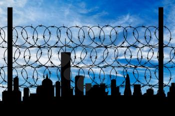 concept of security. Silhouette of barbed wire fence on the background of the city away