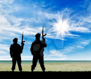 Concept of a terrorist attack. Silhouette of terrorists with a rifle on the beach