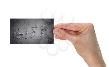 Concept of life and time. Hand with a business card where it is written the word of life. Isolated on white background