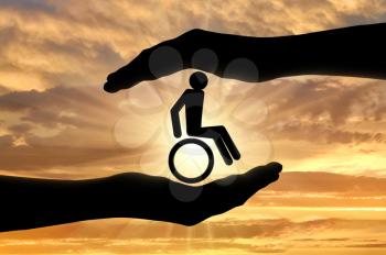Disabled person in a wheelchair in hands. Concept of helping people with disabilities