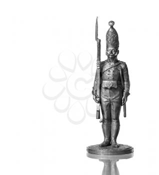 Silver tin soldier on a white background with reflection.