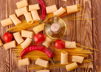 collage Pasta with cherry tomatoes and other ingredients on wooden table background