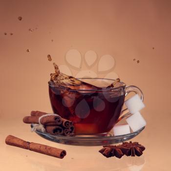 Cup of tea on glass with orange background