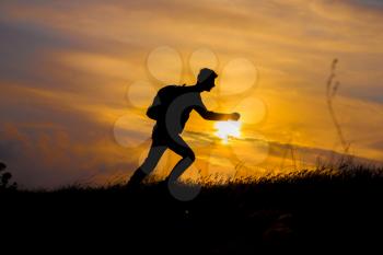 Follow your dreams, silhouette of man at sunset. Hiker with backpack walking in the field. Over sunset. Summer healthy active lifestyle. Single travel.