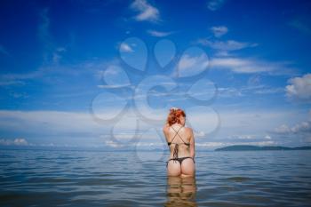 Young fashion woman relax on the beach. Happy island lifestyle. White sand, blue cloudy sky and crystal sea of tropical beach. Vacation at Paradise. Ocean beach relax, travel to Thailand, Krabi