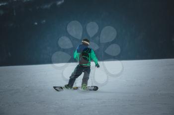 Man snowboarder rides on the slope. ski resort. Space for text. ride in Dombay - a downhill skiing resort in Karachayevo-Cherkesiya, Russia.