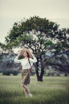 Young red-haired traveler in fairy-tale beautiful scenery. The idea and concept of rest, relaxation, freedom