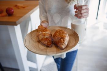 Autumn sseries in the Kitchen, melancholy and warm.. Relaxing in cold weather. red-haired girl holding a tray with pastries and bottle of milk