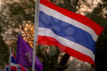 The blowing Thai flag at the sunset. Sukhothai, the old capital of Thailand, historical park