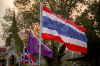 The blowing Thai flag at the sunset. Sukhothai, the old capital of Thailand, historical park