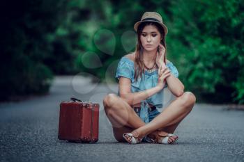 Young beautiful Asian woman in hippy style. travels by hitchhiking. Road in the mountains