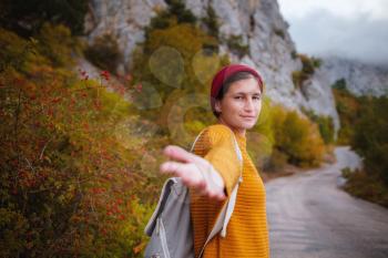 Couple travelers Man and Woman follow holding hands at foggy mountains landscape on background. Follow me - POV.