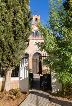 Gate and pathway to  courtyard with a small family church or chapel with belltower