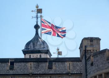 Union Flag rises above the walls of the Tower in London, England, UK
