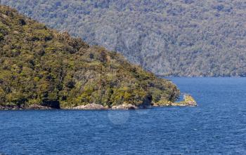 Sailing into Doubtful Sound on South Island of New Zealand aboard a cruise ship with a headland leading the way to the next bay