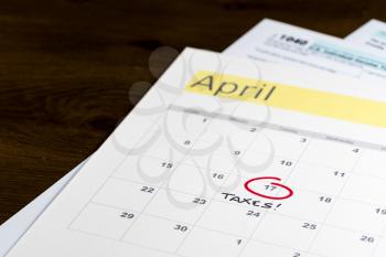 Calendar on top of form 1040 income tax form for 2017 showing tax day for filing is April 17 2018