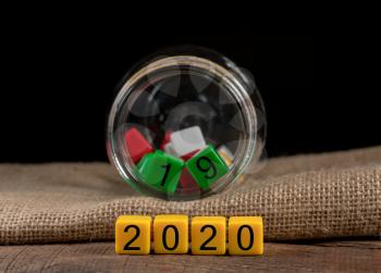 2019 being put back in the jar as dice for 2020 is spread on wooden table for New Years celebrations