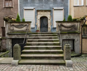 Narrow street with view up solid stone steps to entrance door of home on Mariacka St in Gdansk, Poland
