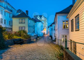 Narrow cobbestone Nedre Strangehagen Street at dusk in the old town of Bergen in Norway