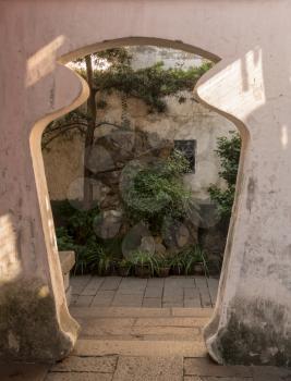 Doorway into small courtyard with tree planting in Yu or Yuyuan Garden in  the old city of Shanghai